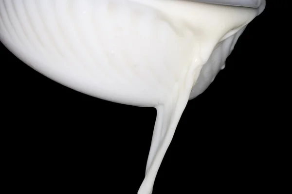Молоко на черном фоне — стоковое фото