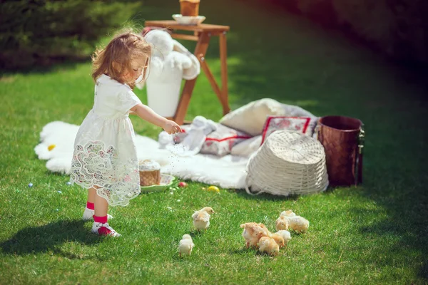 Criança feliz brinca em um prado em torno da decoração de Páscoa — Fotografia de Stock