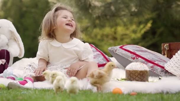Щаслива дитина сидить на лузі навколо Великодня прикраси — стокове відео