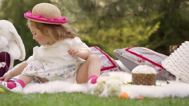 Niño feliz se sienta en un prado alrededor de la decoración de Pascua — Vídeos de Stock