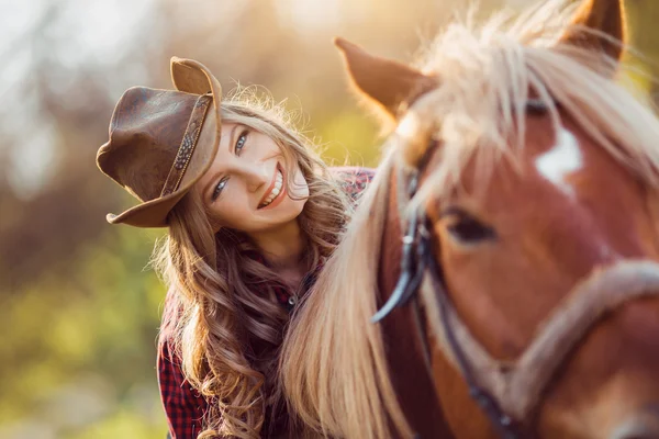 Cowgirl rijpaard op zomer veld — Stockfoto