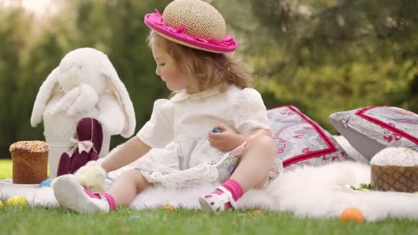 Joyeux enfant assis sur une prairie autour de la décoration de Pâques — Video