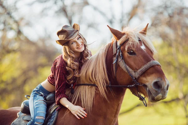 美丽小女孩微笑着在秋天的原野上骑马 — 图库照片