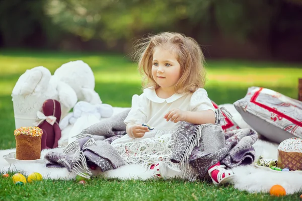 Дитина сидить на лузі навколо Великодня прикраси — стокове фото