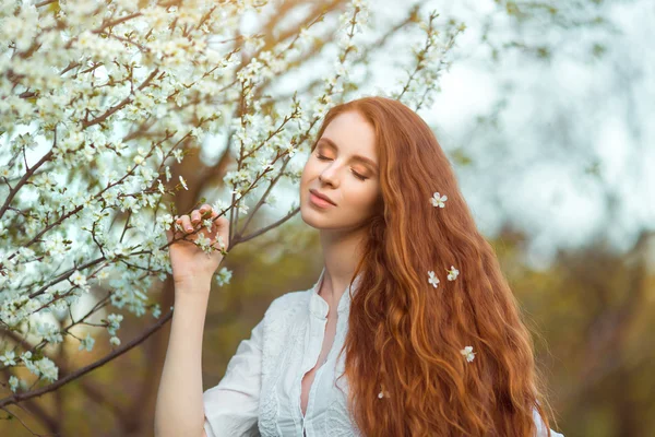 Mooie zwangere vrouw in bloeiende tuin — Stockfoto