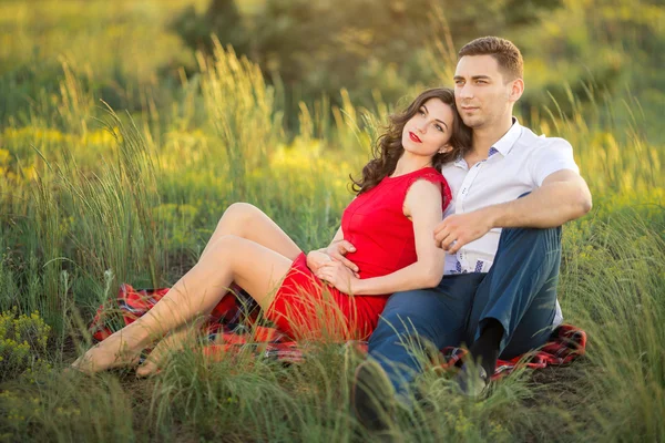 Casal feliz descansando na grama no parque — Fotografia de Stock