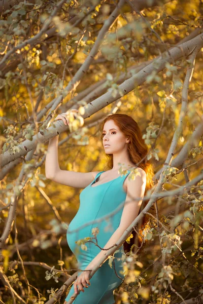 Mooie zwangere vrouw in de tuin — Stockfoto