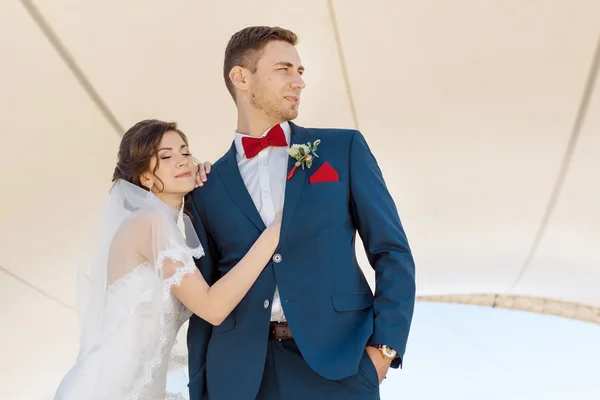 Joven pareja de boda de pie al aire libre — Foto de Stock