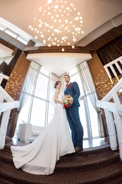 Pasangan pengantin muda berdiri di jendela — Stok Foto