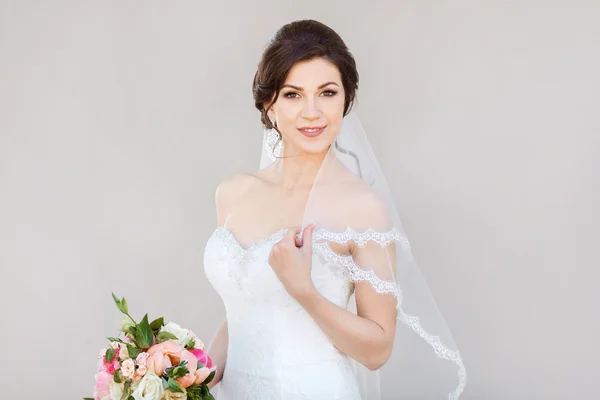 Mosolyog a szürke falon, a gyönyörű menyasszony — Stock Fotó