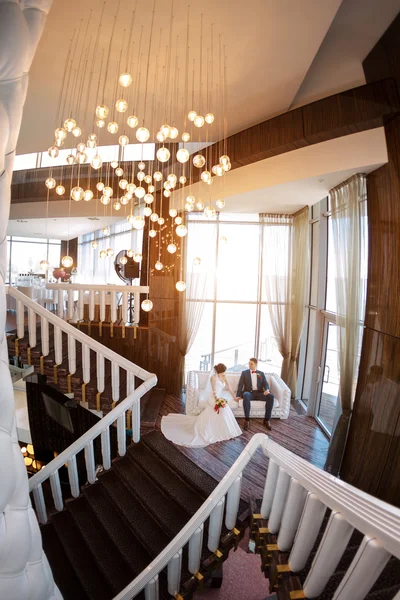 Junges Hochzeitspaar auf Sofa gegen Fenster — Stockfoto