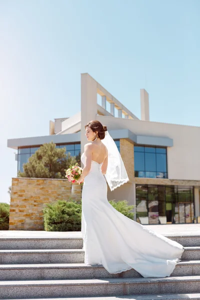 Splendida sposa sexy in abito bianco in posa sulla strada — Foto Stock