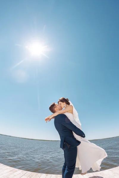 Joven boda pareja besos en muelle — Foto de Stock