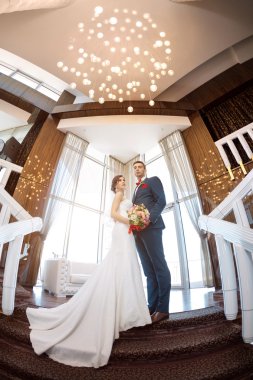 Bir pencere karşı duran genç Düğün çifti