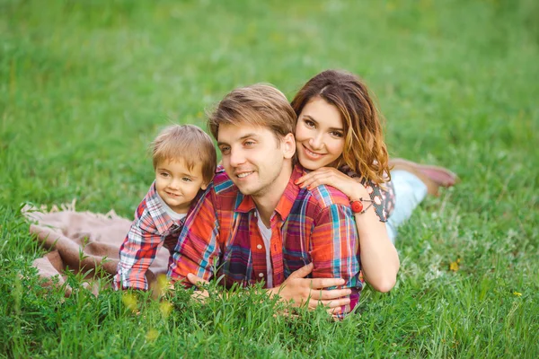 Ευτυχισμένη οικογένεια σε ένα πάρκο στο γρασίδι — Φωτογραφία Αρχείου