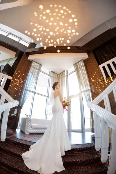 Beautiful bride against a big window indoors — Stock Photo, Image