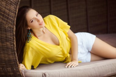 Güzel ve genç birbayan rahatlatıcı ahşap tahta yatakta havuzu yakınlarında