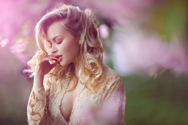 Beautiful sexy adult girl standing at blossoming tree in the garden — Stock Photo, Image