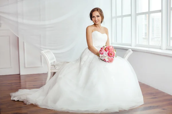 A menyasszony. Fiatal nők esküvői ruha nagyon világos szobában, — Stock Fotó