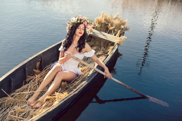 Фотография красивой девушки, сидящей в лодке — стоковое фото