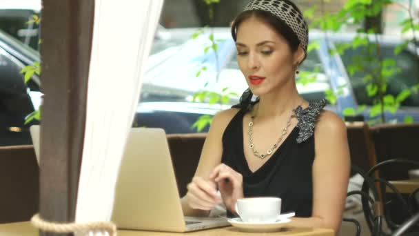 Vrouw die op laptop in café werkt en beantwoording van de oproep, selectieve aandacht — Stockvideo