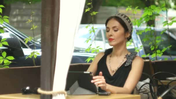 Woman working on tablet in cafe and correcting make-up, selective focus — Stock Video