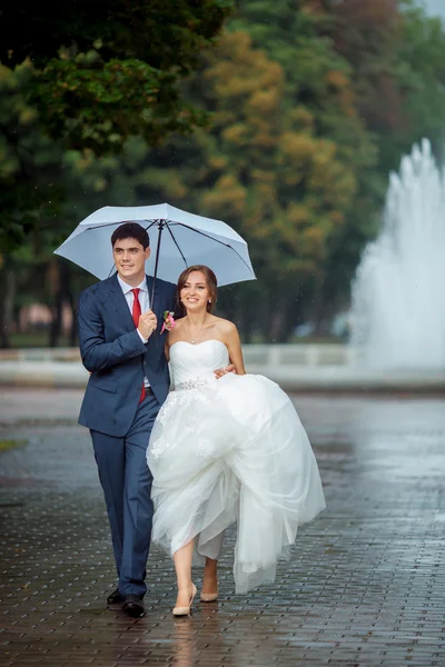 Feliz novia y novio en el paseo de la boda paraguas blanco — Foto de Stock