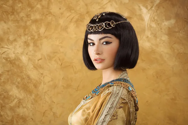 Vacker egyptisk kvinna som Cleopatra på gyllene bakgrund — Stockfoto