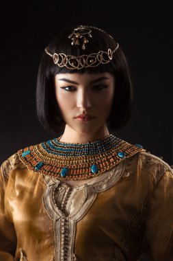 Siyah arka plan üzerinde serius yüzü ile Mısır Kraliçesi Kleopatra gibi güzel kadın