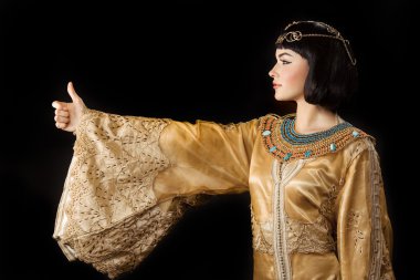 Kleopatra gibi mutlu Mısırlı kadın başparmak yukarı jest ile, izole siyah arka plan üzerinde
