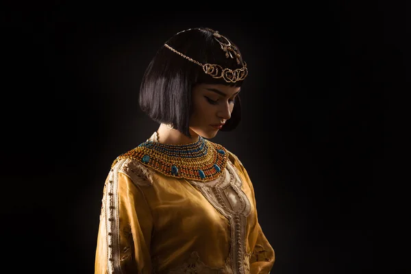 黒い背景に悲しい顔を持つエジプトの女王クレオパトラのような美しい女性 — ストック写真