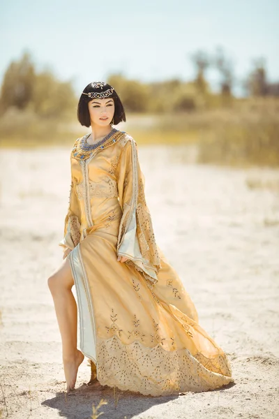 Szép nő, mint az egyiptomi királynő Kleopátra a sivatagban szabadtéri. — Stock Fotó