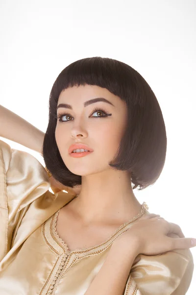 Sensual girl with Cleopatras make-up and haircut posing in studio — Stock Photo, Image