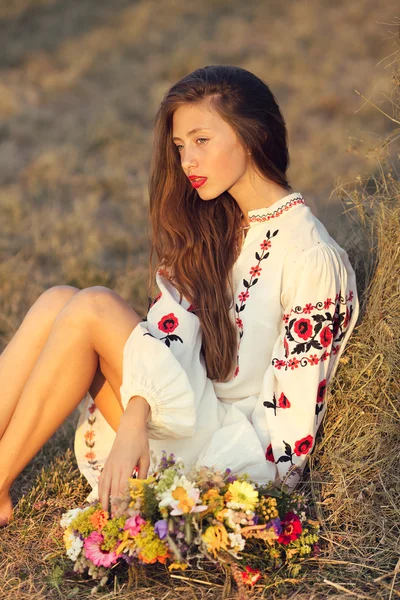 Beautiful girl in meadow in national suite — Stock Photo, Image