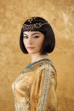 Altın arka plan serius yüzünde güzel bir kadınla Mısır Kraliçesi Kleopatra gibi