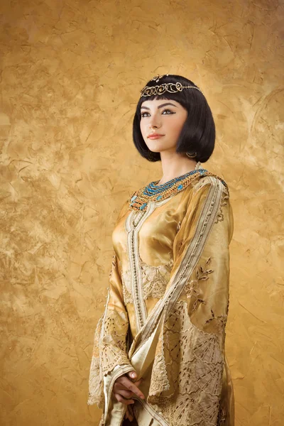 Bella donna come la regina egiziana Cleopatra su sfondo dorato — Foto Stock