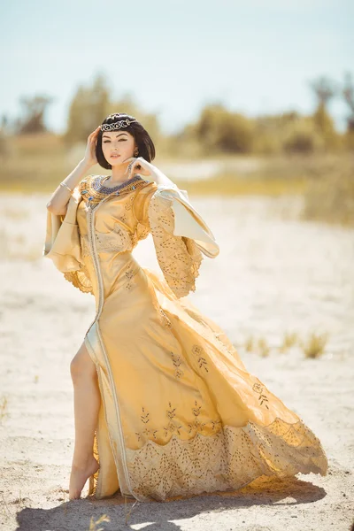 Belle femme comme la reine égyptienne Cleopatra sur dans le désert en plein air . — Photo