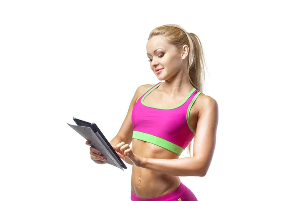 Menina aptidão desportiva usando tablet pc no fundo branco isolado — Fotografia de Stock