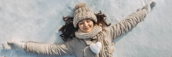 Женщина, лежащая на снегу — стоковое фото