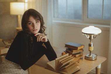 Kadın evde kitap okuyor.