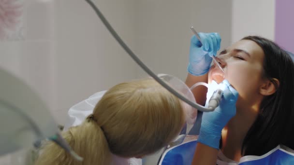 Dokter gigi melakukan perawatan gigi pada pasien perempuan. — Stok Video
