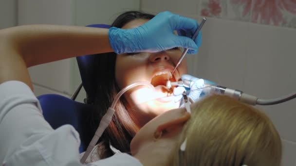 Tandläkare som gör en tandvård på en kvinnlig patient. — Stockvideo