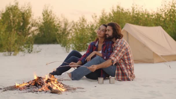 Camping de cuplu turistic lângă focul de tabără în aer liber pe natură — Videoclip de stoc