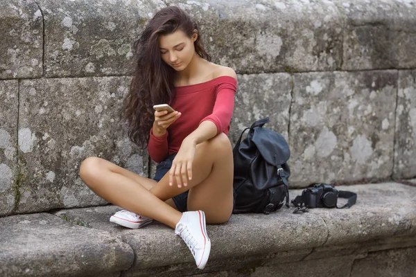 Žena s batohem, telefonem a fotoaparátem na City Street — Stock fotografie