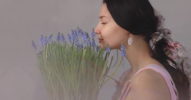Kobieta trzyma bukiet kwiatów w dłoniach w pomieszczeniach — Wideo stockowe