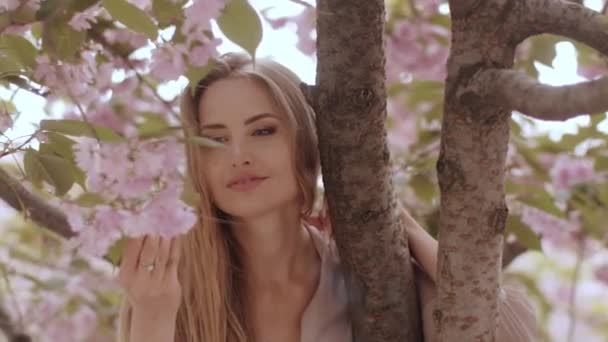 Tavaszi szépség portré egy nő a virágzó Sakura fa a természetben — Stock videók