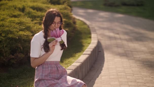 Mujer con flores al aire libre en el parque de la ciudad — Vídeo de stock