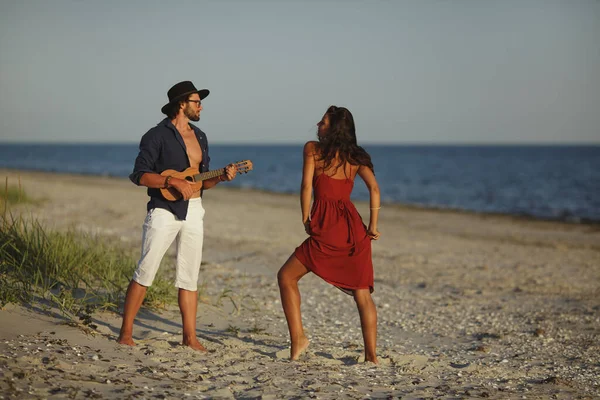 Coppia innamorata che suona la chitarra e balla sulla spiaggia — Foto Stock