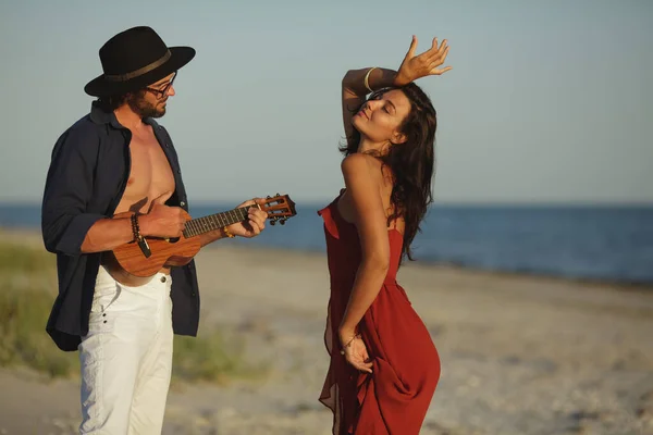 Coppia innamorata che suona la chitarra e balla sulla spiaggia — Foto Stock