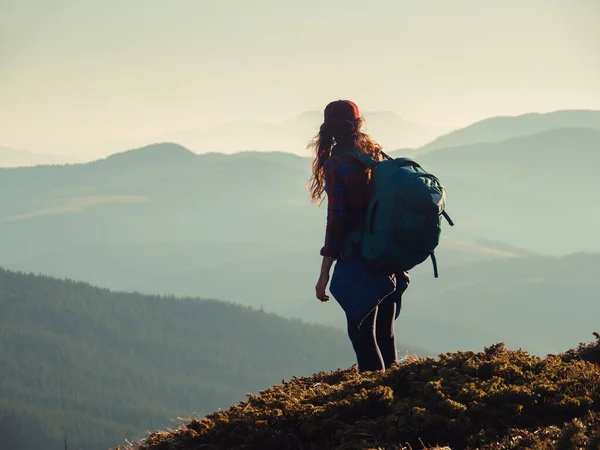 Mulher caminhante com mochila no topo de uma montanha — Fotografia de Stock